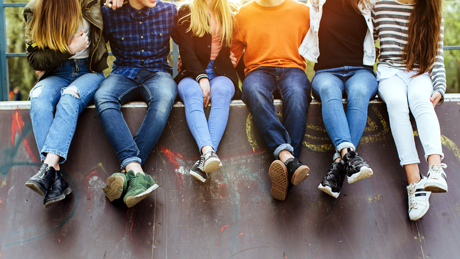 Groupe de jeunes gens assis sur un muret